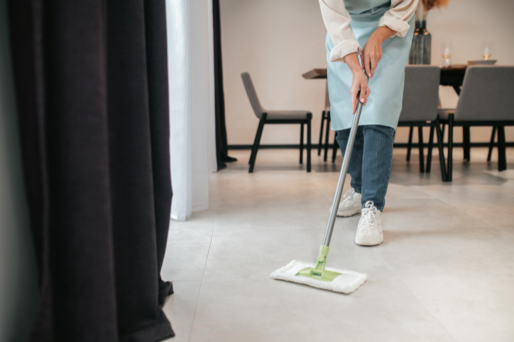 A person mopping the floor of a bright, modern home